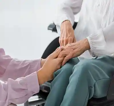young-and-senior-women-holding-hands-in-nursing-ho-DC984U7